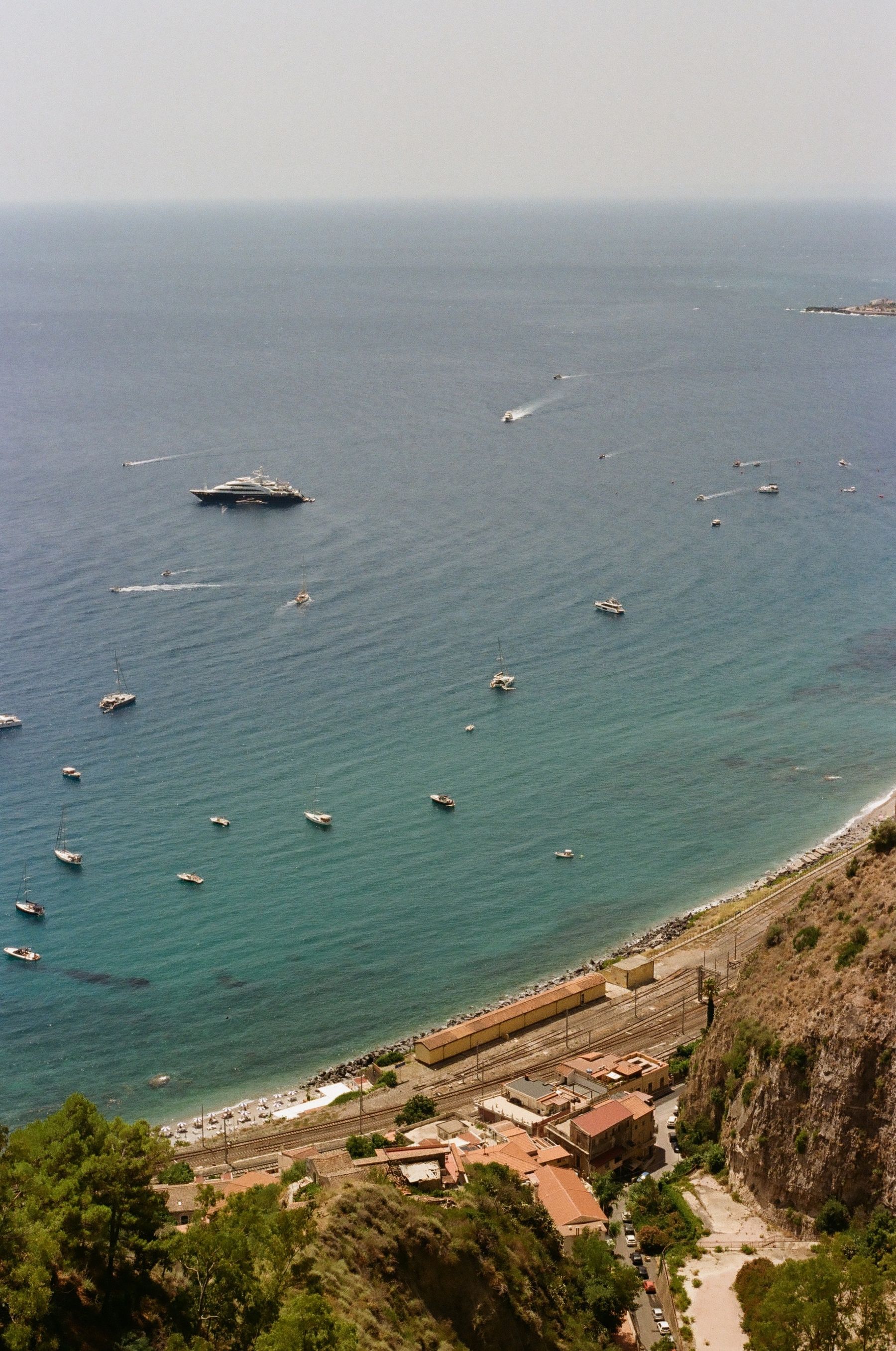 View over the Ionian Sea, boats and railway below Taormina