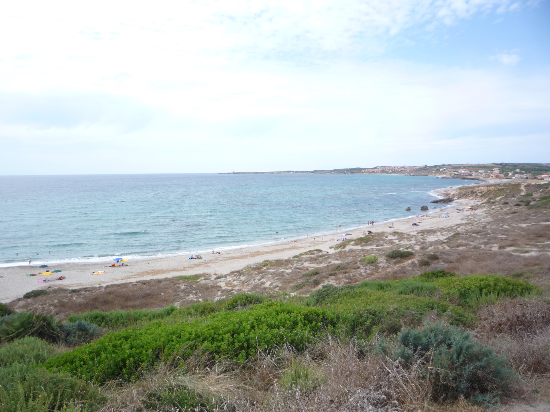 Pale beach, clear sea and low cliffs in western Sardinia